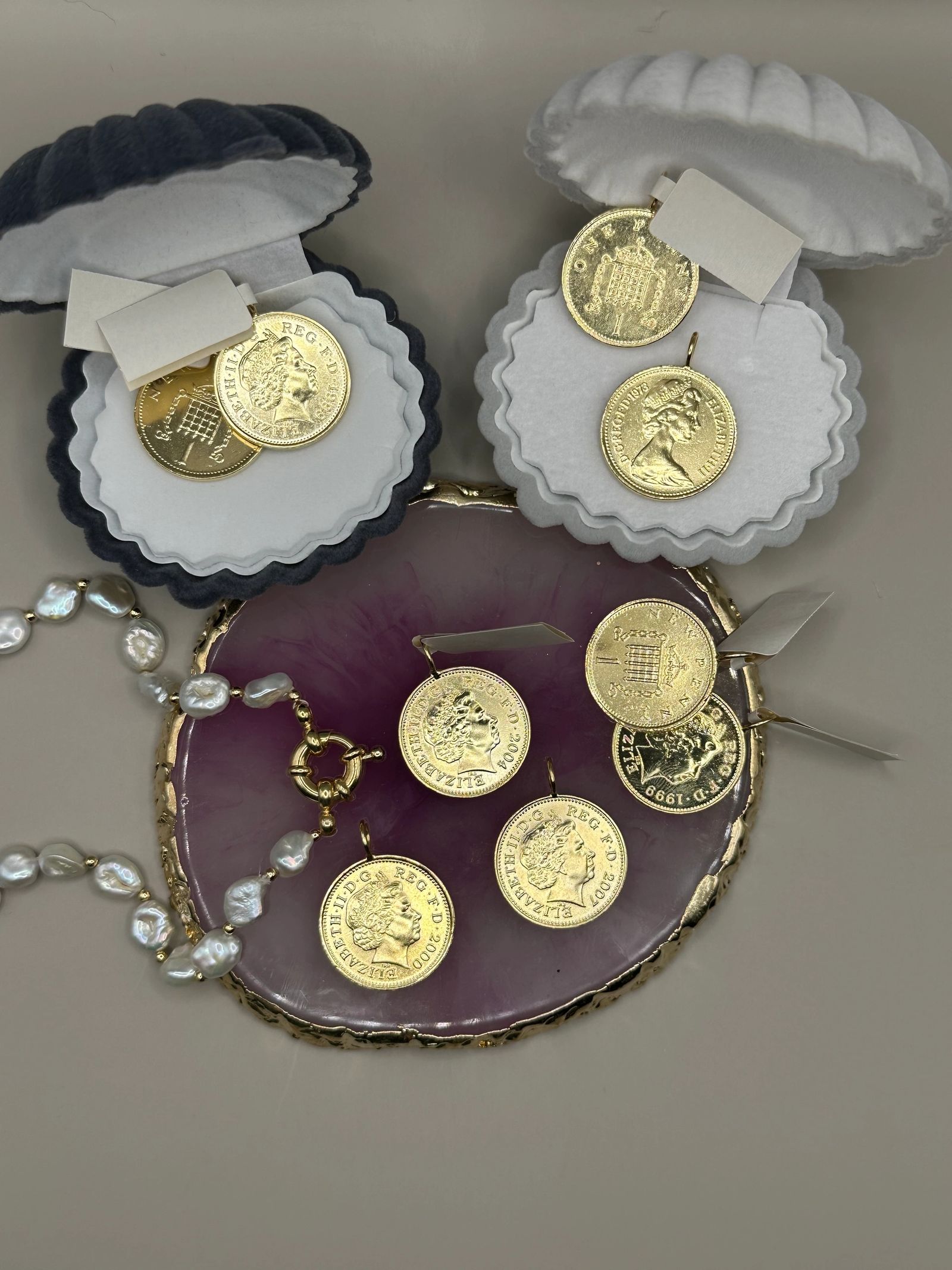Collection of Elizabeth II coin charms in shell boxes
